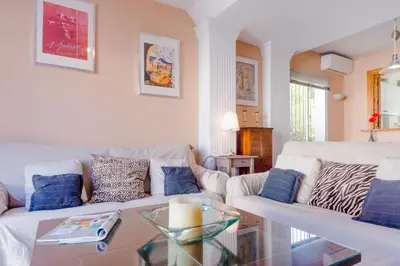a living room with a white couch and a glass table at Duplex El Manantial in El Puerto de Santa María