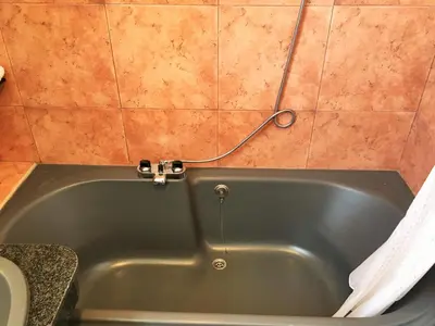 a green bath tub in a bathroom with a toilet at Duplex El Manantial in El Puerto de Santa María