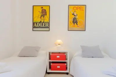 two beds in a room with posters on the wall at Duplex El Manantial in El Puerto de Santa María