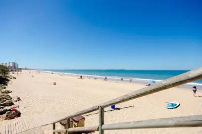 a beach with a bunch of people on it at Duplex El Manantial in El Puerto de Santa María
