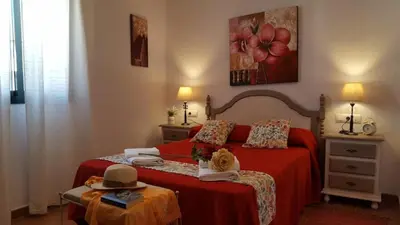 a bedroom with a bed with a hat on it at Chalet Las Adelfas Chaparrillo in Conil de la Frontera