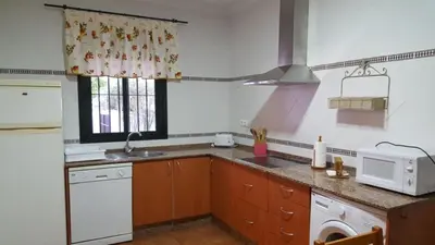a kitchen with a sink and a microwave at Chalet Las Adelfas Chaparrillo in Conil de la Frontera