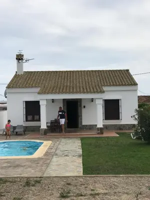 a man standing in front of a white house at Chalet La Primera Piedra in Conil de la Frontera