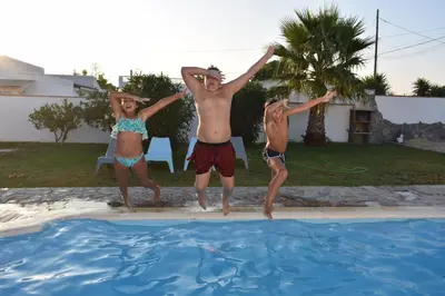 three young children jumping into a swimming pool at Chalet La Primera Piedra in Conil de la Frontera