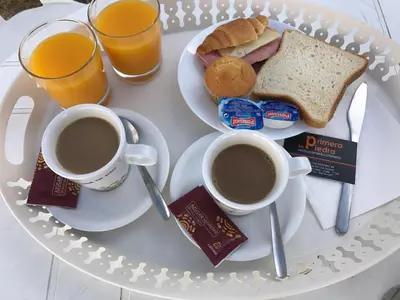 a white plate with two cups of coffee and toast at Alojamiento Rural La Mejora in Conil de la Frontera