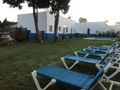 a row of blue and white lounge chairs in a yard at Alojamiento Rural La Mejora in Conil de la Frontera
