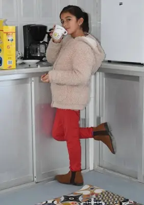 a woman standing in a kitchen holding a coffee cup at Alojamiento Rural La Mejora in Conil de la Frontera