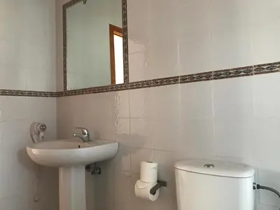 a bathroom with a sink and a toilet and a mirror at Alojamiento Rural La Mejora in Conil de la Frontera