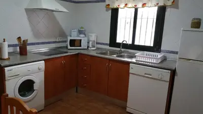 a kitchen with a sink and a washing machine at Chalet Roche - Pilahito in Conil de la Frontera
