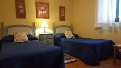 two beds in a room with blue sheets at Chalet Roche - Pilahito in Conil de la Frontera