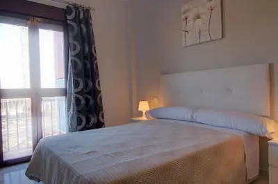 a bedroom with a large bed and a window at Apartamentos Centro 1 El Puerto de Santa Maria in El Puerto de Santa María
