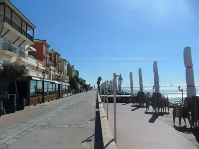 a street with chairs and tables on a beach at estudio marina puerto sherry in El Puerto de Santa María