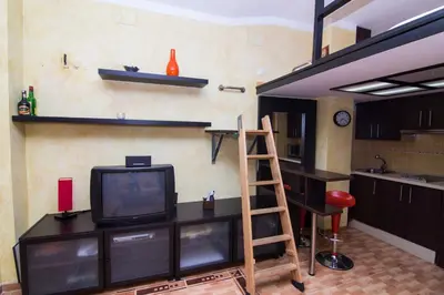 a living room with a tv and a ladder at estudio marina puerto sherry in El Puerto de Santa María