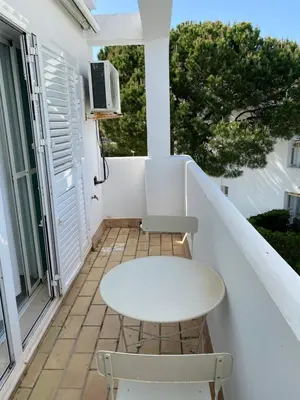 a white table and two chairs on a balcony at Apartamento Retama Golf I in Chiclana de la Frontera