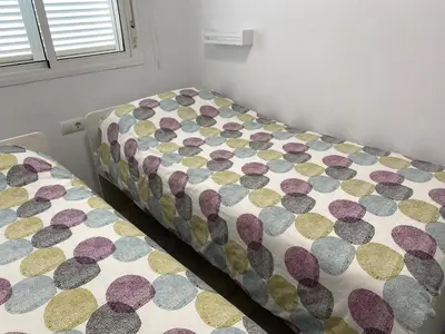 a bedroom with two twin beds with a bedspread at Apartamento Retama Golf I in Chiclana de la Frontera
