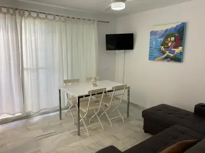 a living room with a table and a couch at Apartamento Retama Golf I in Chiclana de la Frontera