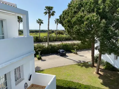 a car parked in a parking lot next to a house at Apartamento Retama Golf I in Chiclana de la Frontera