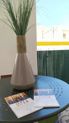 a vase sitting on a table with a plant in it at Sherryflat Mérito - Parking in Jerez de la Frontera