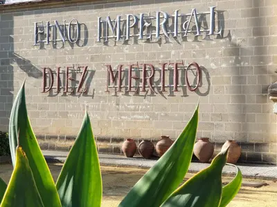 a brick wall with a sign that saysippi imperial dipma at Sherryflat Mérito - Parking in Jerez de la Frontera