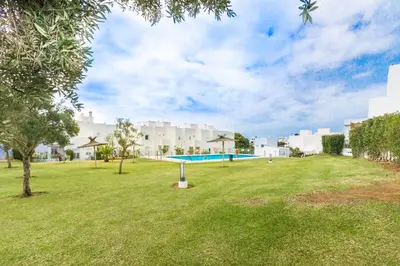 a park with a swimming pool in front of a building at Duplex Camino del Tejar in Conil de la Frontera