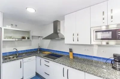 a white kitchen with white cabinets and a sink at Duplex Camino del Tejar in Conil de la Frontera