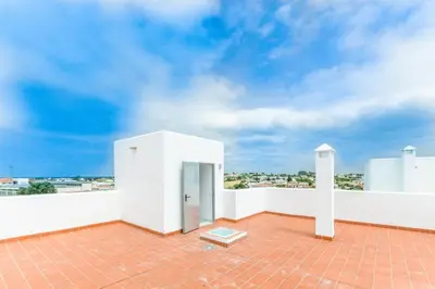 a white building with a door on a roof at Duplex Camino del Tejar in Conil de la Frontera