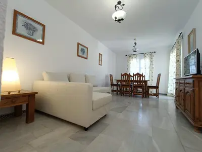 a living room with a white couch and a table at Sancti Petri Marinero in Chiclana de la Frontera