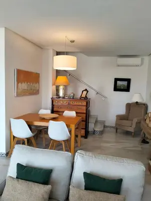 a living room with a table and chairs at Casa Sargo in Chiclana de la Frontera