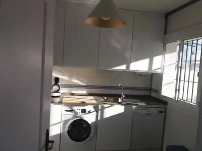 a kitchen with a washing machine and a washer at Casa Sargo in Chiclana de la Frontera