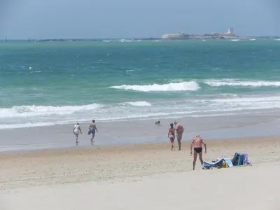 a group of people walking on the beach at Casa Sargo in Chiclana de la Frontera