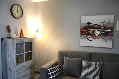 a living room with a couch and a clock on the wall at Apartamento El Mirador de Cadiz in Cádiz