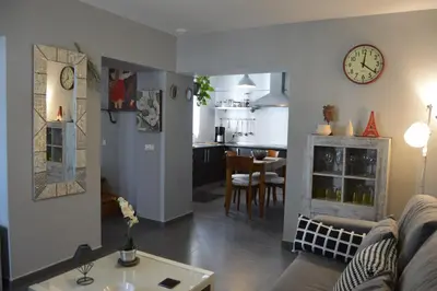 a living room and kitchen with a clock on the wall at Apartamento El Mirador de Cadiz in Cádiz