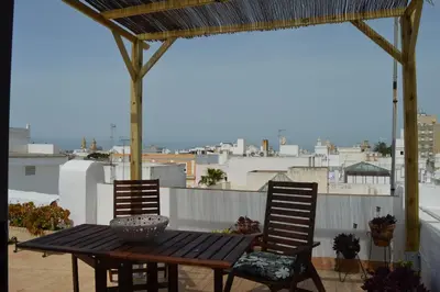 a wooden table and two chairs on a balcony at Apartamento El Mirador de Cadiz in Cádiz