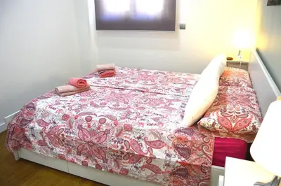 a small bedroom with a bed with a flowered blanket at Apartamento Recreo Cadiz in Cádiz