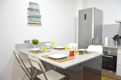 a kitchen with a white table and chairs at Apartamento Recreo Cadiz in Cádiz