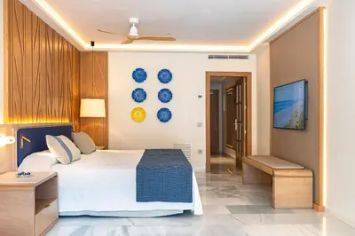 a bedroom with a desk with a mirror and a bed at Hipotels Barrosa Palace & Spa in Chiclana de la Frontera
