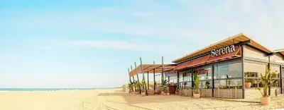 a kitchen and living room with a table and chairs at Hipotels Barrosa Palace & Spa in Chiclana de la Frontera