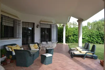 a patio with couches and chairs on a house at Villa las Redes in El Puerto de Santa María