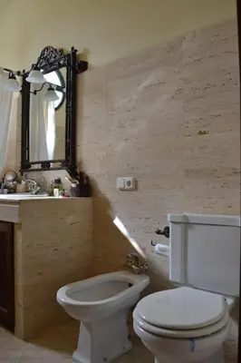 a bathroom with a toilet and a sink and a mirror at Villa las Redes in El Puerto de Santa María