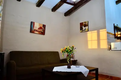a living room with a couch and a table with flowers at Cortijo Mesa de la Plata in Arcos de la Frontera