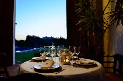 a table with wine glasses and a candle on it at Cortijo Mesa de la Plata in Arcos de la Frontera