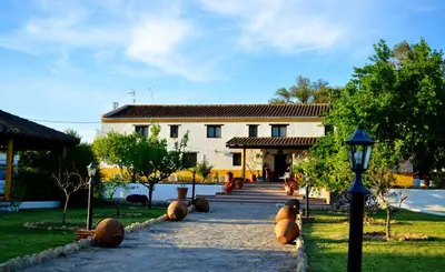 a building with a garden with large teddy bears on the sidewalk at Cortijo Mesa de la Plata in Arcos de la Frontera