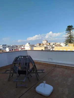 a chair and a bowl on a roof at Apartamentos Fariñas 11 in Sanlúcar de Barrameda