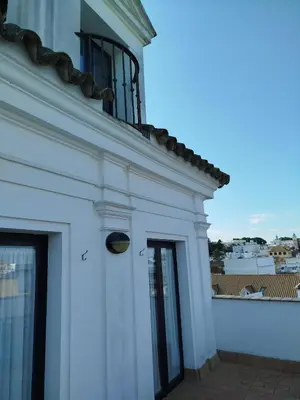 a white building with a window and a balcony at Apartamentos Fariñas 11 in Sanlúcar de Barrameda