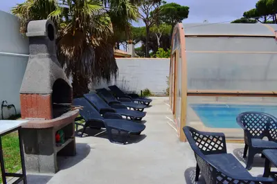 a row of chairs sitting next to a swimming pool at Sancti Petri House in Chiclana de la Frontera