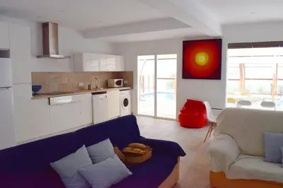 a living room with a blue couch and a kitchen at Sancti Petri House in Chiclana de la Frontera