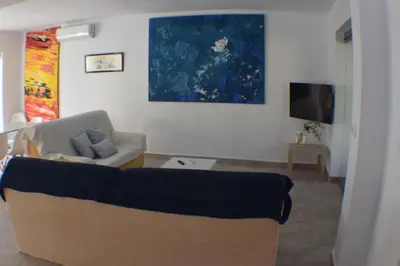 a living room with a couch and a tv at Sancti Petri House in Chiclana de la Frontera