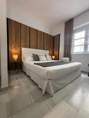 a bedroom with a large bed with wooden walls at ISA Cádiz in Cádiz