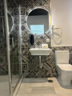 a bathroom with a sink and a toilet and a mirror at ISA Cádiz in Cádiz