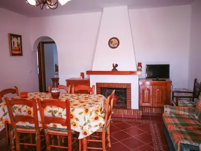 a dining room with a table and a fireplace at Villa Juan in Conil de la Frontera